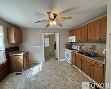 Petersburg house for rent - A kitchen with a fan and a refrigerator.