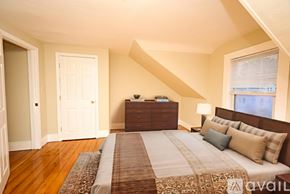 Braintree townhouse for rent - A bedroom with a large bed and a wooden floor.