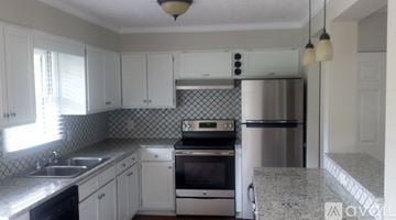 Candler townhouse for rent - A kitchen with white cabinets and a granite counter top.