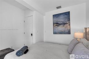 Miami condo for rent - A bedroom with a large bed and a painting on the wall.