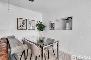 Miami condo for rent - A modern dining room with a glass table and chairs.
