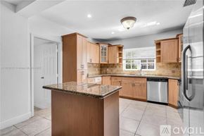 Miami condo for rent - A kitchen with wooden cabinets and a granite countertop.