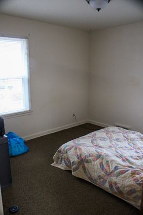 Fremont apartment for rent - A bedroom with a bed, a window, and a blue bag on the floor.