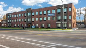 Oak Park apartment for rent - A building with a sign that says "NOW LEASING" on the side of it.