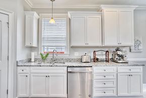 Greer house for rent - A kitchen with white cabinets and a granite countertop.