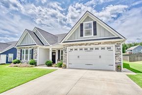 Greer house for rent - A two-car garage is attached to a house with a blue and white exterior.