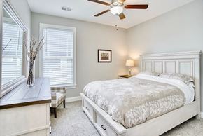 Greer house for rent - A bedroom with a large bed and a ceiling fan.