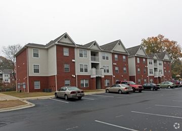 Memphis apartment for rent - A parking lot with cars and apartment buildings.