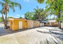 Los Angeles house for rent - A yellow house with a white fence and a tree in front.
