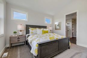 Lake Elmo house for rent - A bedroom with a large bed and a nightstand with a lamp.