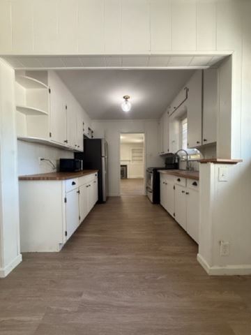 Charlotte house for rent - A kitchen with white cabinets and a black refrigerator.