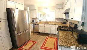 Kapaa apartment for rent - A kitchen with a black fridge and white cabinets.