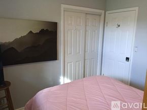 Kapaa apartment for rent - A bedroom with a pink bedspread and a painting on the wall.