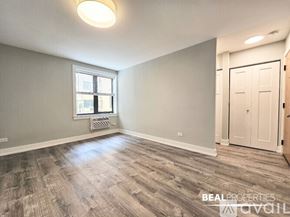 Chicago condo for rent - A room with wooden flooring and a window with blinds.