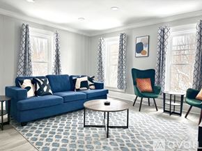 Watertown apartment for rent - A living room with a blue couch, two chairs, and a coffee table.