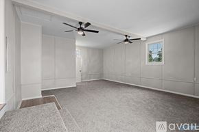 Athens house for rent - A spacious room with a ceiling fan and a window.