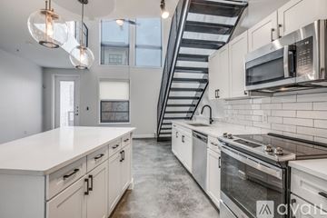 Dallas apartment for rent - A kitchen with white cabinets and a stainless steel stove top.