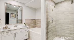 Dallas apartment for rent - A bathroom with a white vanity and a walk-in shower.