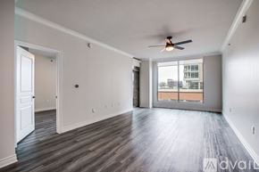 Dallas apartment for rent - A spacious room with a ceiling fan and wooden flooring.