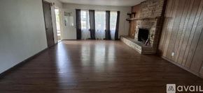 Highland house for rent - A spacious room with wooden floors and a fireplace.
