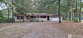 Highland house for rent - A house with a brown roof is surrounded by trees.