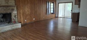 Highland house for rent - A living room with wood floors and a stone fireplace.