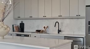 Dallas apartment for rent - A kitchen with white cabinets and a marble backsplash.