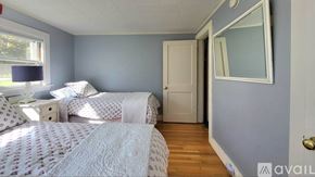 Wells house for rent - A bedroom with two beds and a mirror on the wall.