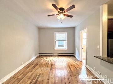 Chicago apartment for rent - A kitchen with dark wood cabinets and granite countertops.