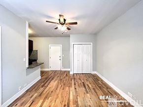 Chicago apartment for rent - A spacious room with wood flooring and white walls.