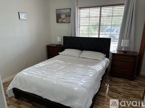 Henderson apartment for rent - A bedroom with a large bed, wooden nightstands, and a window with blinds.