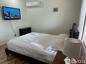 Henderson apartment for rent - A bedroom with a bed, a television, and a lamp.