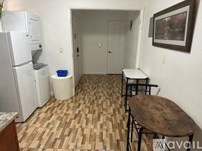 Henderson apartment for rent - A kitchen area with a refrigerator, a table, and chairs.