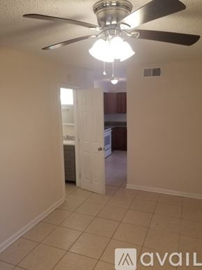 New Orleans apartment for rent - A room with a ceiling fan and a light fixture.