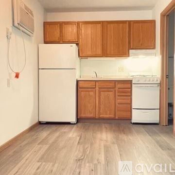 La Crosse apartment for rent - A kitchen with wooden cabinets and white appliances.