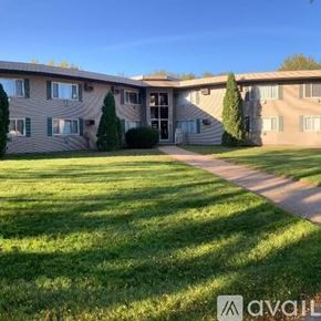 La Crosse apartment for rent - A grassy area in front of a building with a pathway leading to the entrance.