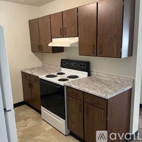La Crosse apartment for rent - A kitchen with a white stove top oven and brown cabinets.