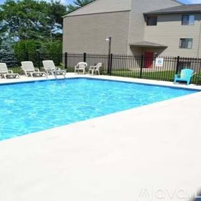 La Crosse apartment for rent - A swimming pool with chairs around it and a building in the background.