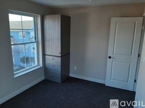 Lowell apartment for rent - A two-story house with a grey facade and white trim.
