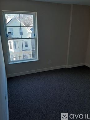 Lowell apartment for rent - A room with a large window overlooking a white house.