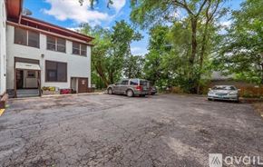 Elgin apartment for rent - A parking lot with a building and two cars.