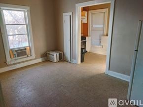 Elgin apartment for rent - A white toilet in a bathroom with a glass shower door.