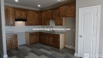 Cleburne apartment for rent - A kitchen with wooden cabinets and a white door.