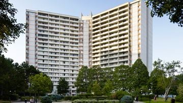 Toronto apartment for rent - A large building with a lot of windows is surrounded by trees.