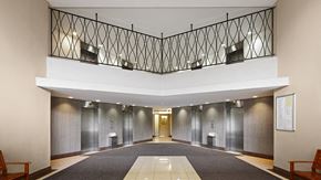 Toronto apartment for rent - A hallway with a black railing and a white ceiling.