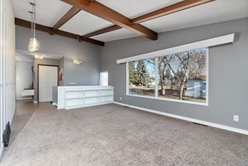 Edmonton apartment for rent - A spacious living room with a white sofa and a large window showing an outdoor view.