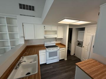 Boulder apartment for rent - A kitchen with white cabinets and a wooden countertop.