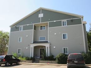 Des Moines apartment for rent - A grey two story building with a car parked in front.