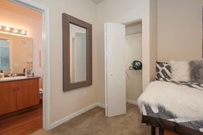 Sacramento apartment for rent - A bedroom with a bed, dresser, mirror, and a nightstand with a lamp.
