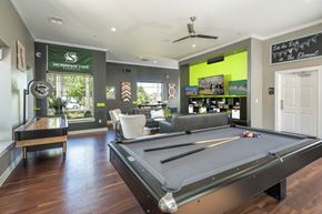 Sacramento apartment for rent - A pool table is in the middle of a room with a green wall and a sign that says "Sacramento State.".